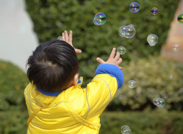 Bebê jogando bolhas de sabão — Fotografia de Stock