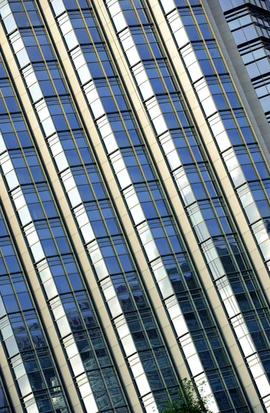 Gekipptes Bauwerk mit funkelnder Glasvorhangwand — Stockfoto