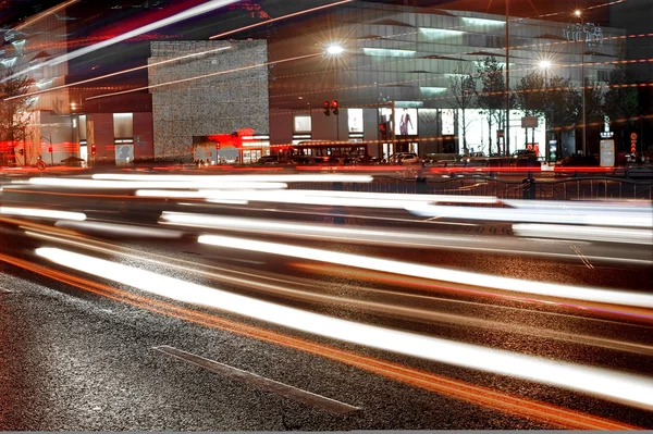 Alta velocidade e carros embaçados trilhas de luz no centro da cidade paisagem noturna — Fotografia de Stock