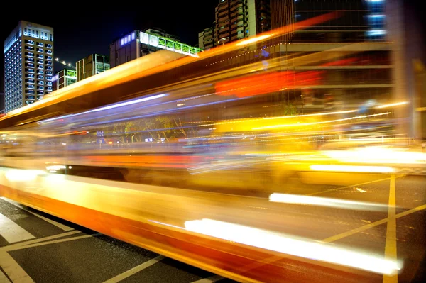 Trilhas leves de ônibus de alta velocidade e embaçadas no centro da cidade — Fotografia de Stock