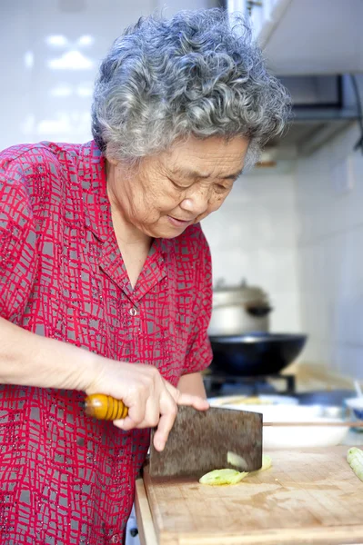 A grandmother is cooking in kitchen — Stock Photo, Image