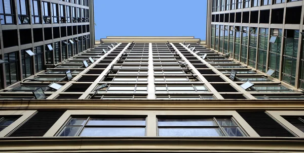 Característica edifício inclinado com parede de cortina de vidro espumante — Fotografia de Stock