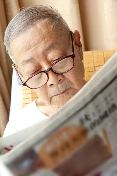 stock image A senior man is reading newspaper