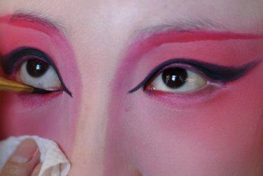 A chinese opera actress is painting her face clipart