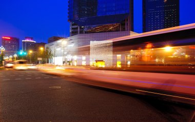 High speed and blurred bus light trails in downtown nightscape clipart