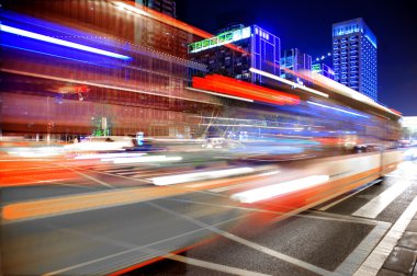 High speed and blurred bus light trails in downtown nightscape clipart