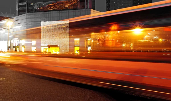 Hög hastighet och suddiga bussen lätta stigar i downtown nightscape — Stockfoto