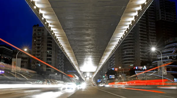 Nachtszene in der Stadt: Überführung, Licht und rasendes Auto — Stockfoto