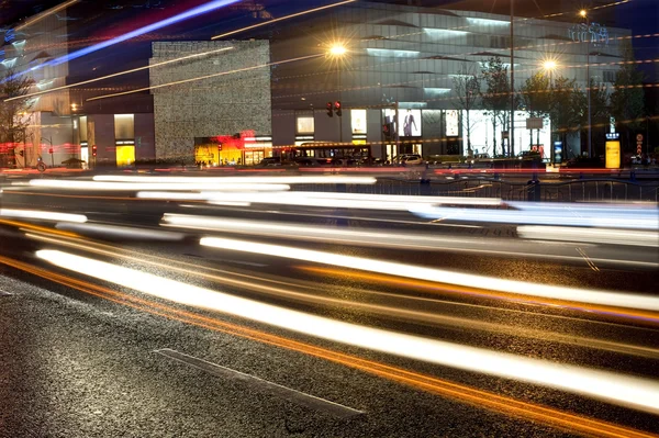 Pistas de luz de alta velocidad y coches borrosos en el paisaje nocturno del centro —  Fotos de Stock