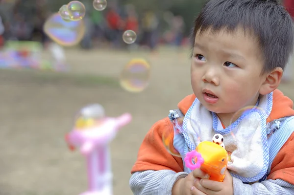 Dítě fouká mýdlové bubliny — Stock fotografie