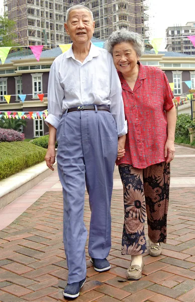 Um casal de idosos íntimos estão andando — Fotografia de Stock
