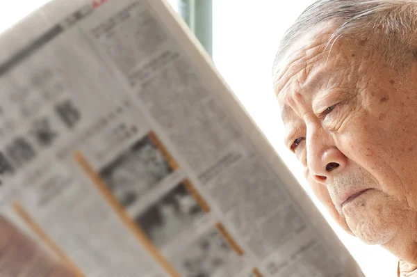 stock image A senior man is reading newspaper