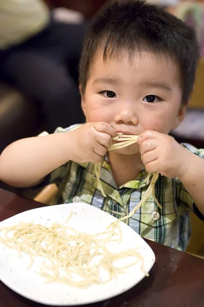 Jíst dítě chytit těstoviny — Stock fotografie