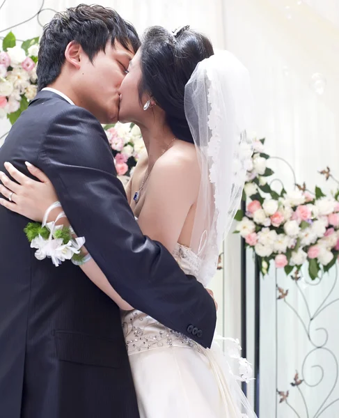 Молодая пара обнимается и целуется в день своей свадьбы — стоковое фото