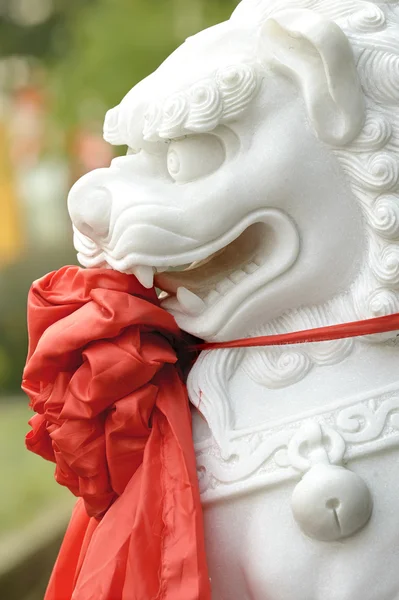 Leão escultura tradicional chinesa com seda vermelha — Fotografia de Stock