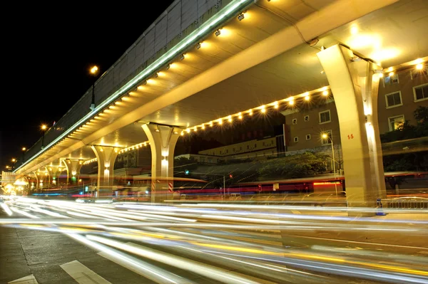 Hoge snelheid verkeer en wazig licht paden onder het viaduct Stockafbeelding