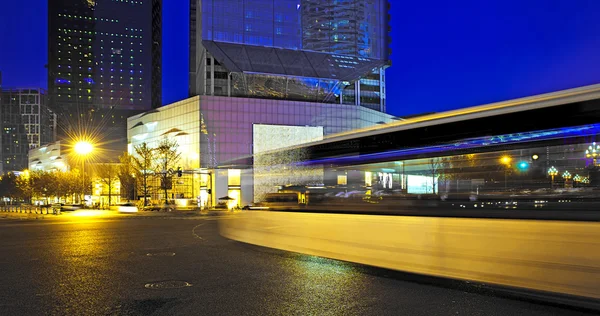 Rutas de luz de autobús borrosas y de alta velocidad en el paisaje nocturno del centro —  Fotos de Stock
