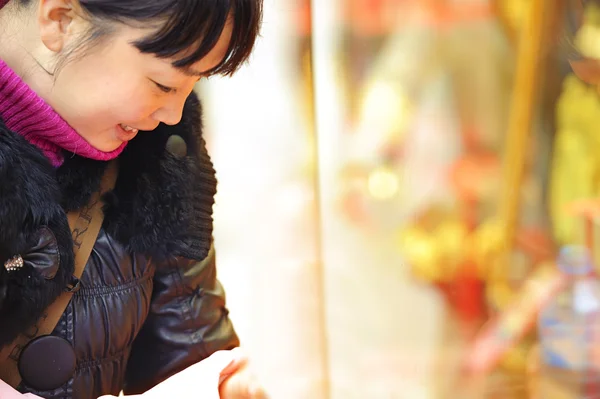 A girl stop to look in the window of a gold shop — Stock Photo, Image