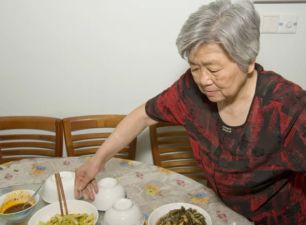 Die Großmutter bereitet das Abendessen zu — Stockfoto