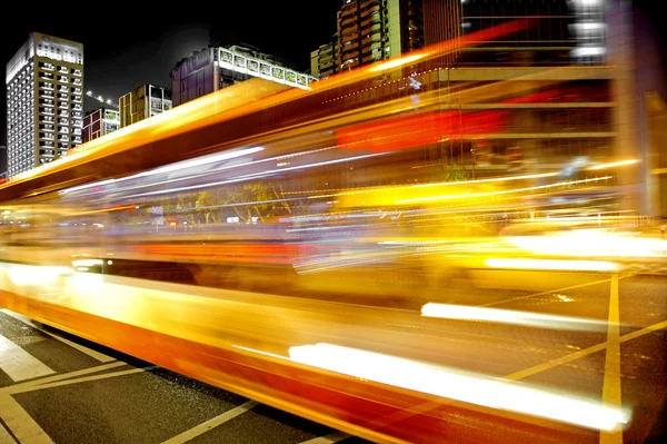High speed and blurred bus light trails in downtown nightscape — Zdjęcie stockowe