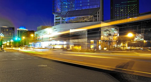 Rutas de luz de autobús borrosas y de alta velocidad en el paisaje nocturno del centro —  Fotos de Stock