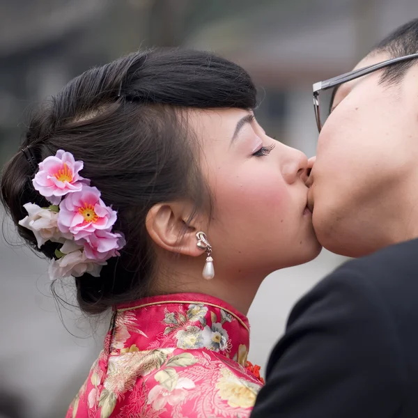 Una giovane coppia che abbraccia e bacia il giorno del loro matrimonio — Foto Stock