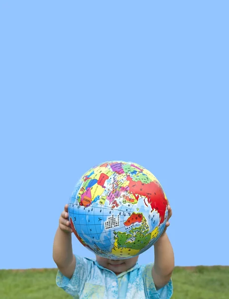 Boy holding the earth model on the grass — Stock Photo, Image