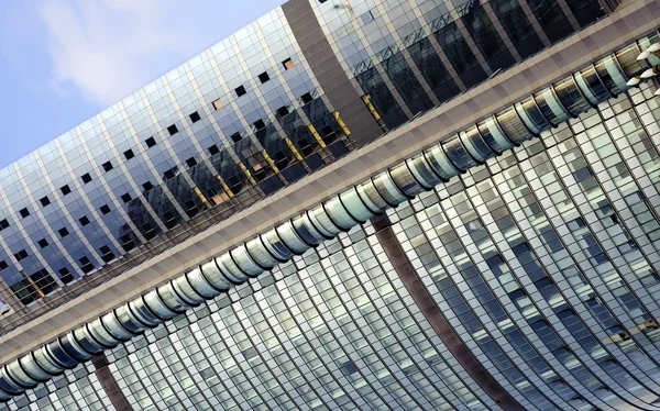 Característica edifício inclinado com parede de cortina de vidro espumante — Fotografia de Stock