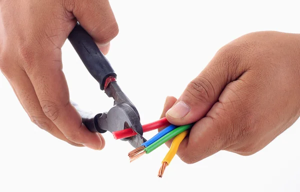 La mano del hombre sostiene el cortador de alambre para desnudar el cable eléctrico mientras sostiene —  Fotos de Stock