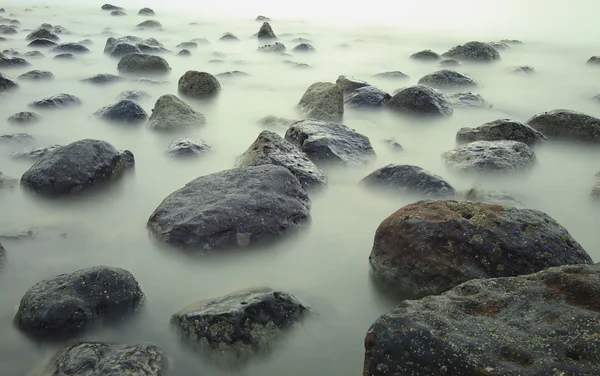 Exposição longa impressionante e rochas na praia . — Fotografia de Stock