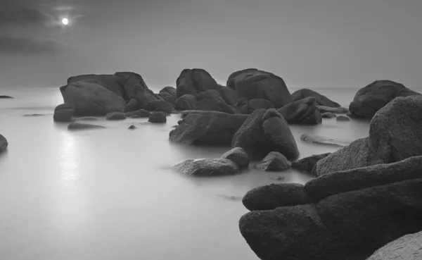 Plajda kayalar ile çarpıcı siyah-beyaz uzun pozlama. — Stok fotoğraf