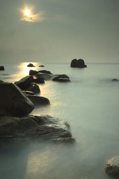 Stunning long exposure beach with rocks at sunrise. — Stock Photo, Image