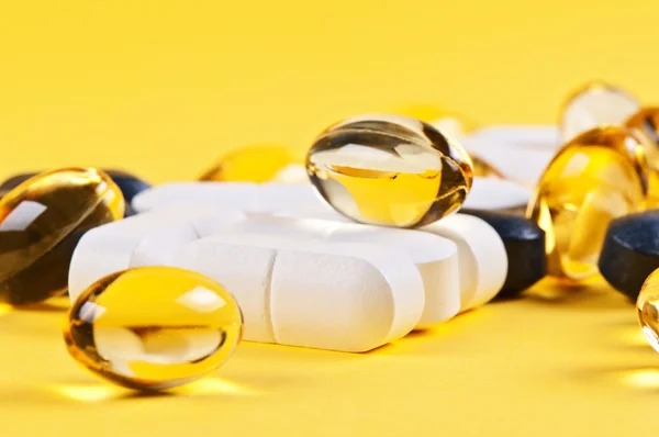 Tabletki na żółtym tle — Zdjęcie stockowe