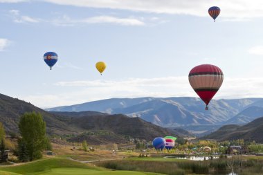 Beautiful mountain landscape with colorful hot balloons. clipart