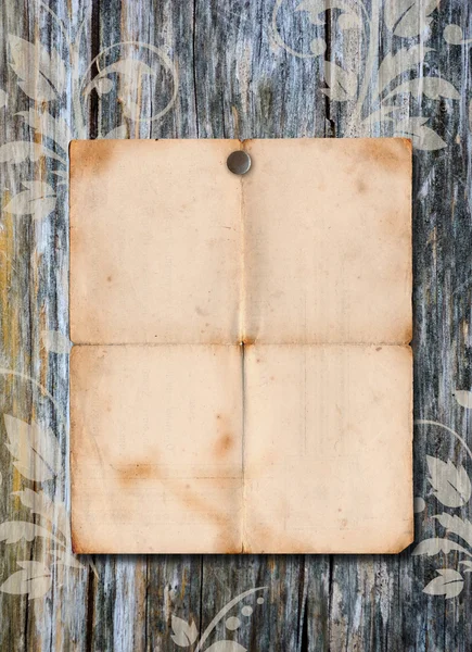 Cartaz de papel velho em uma parede de madeira — Fotografia de Stock