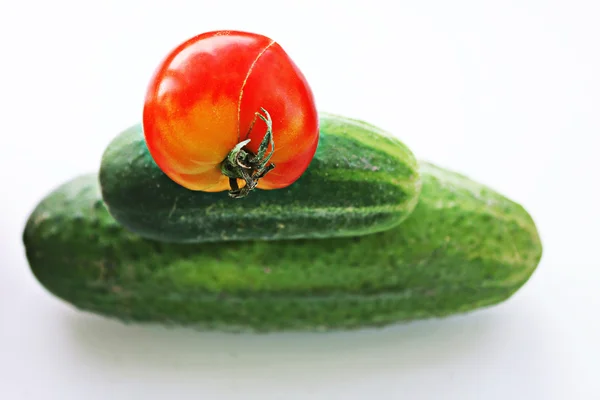 Tomato lies on cucumbers — Stock Photo, Image