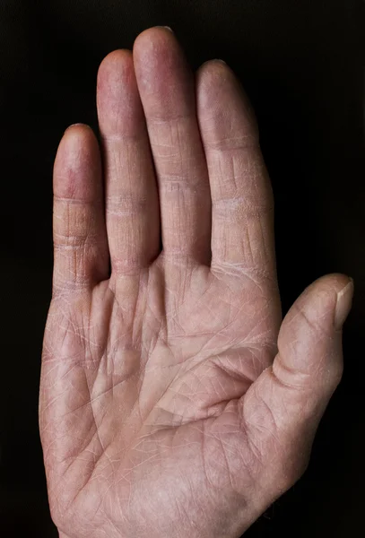 stock image Palm of old man on black background