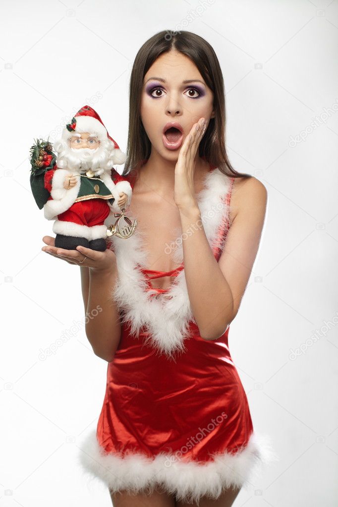 Beautiful and sexy woman wearing santa clause costume holding santa clause