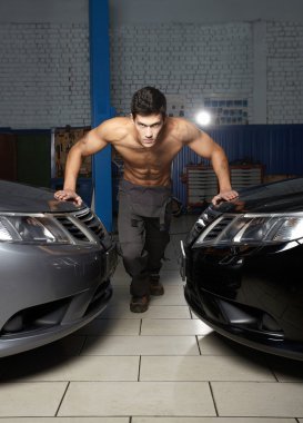 Fashion portrait of a young muscular man standing near the car clipart