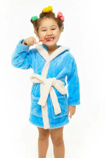 Lykkelig jente pusser tennene i blå morgenkåpe – stockfoto