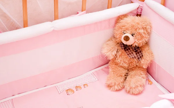 Medvídek v dětskou postýlku — Stock fotografie
