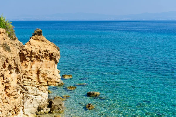 Transparant turquoise zee, zand rots — Stockfoto