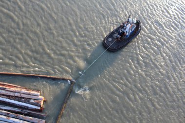 A Tugboat Pulling a Boom clipart