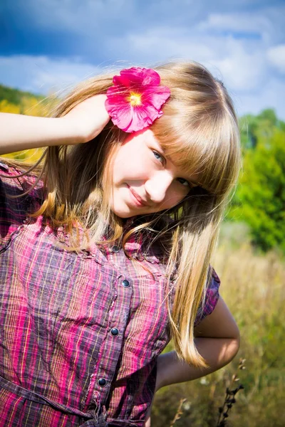 Chica bonita con flor rosa en el pelo — Foto de Stock
