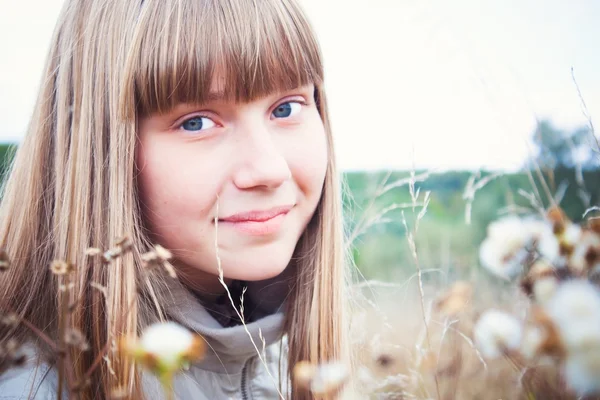 Chica sonriente en un prado en otoño — Foto de Stock