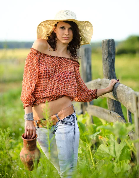 Beautiful girl in a straw hat for a walk in the countryside — Stock Photo, Image