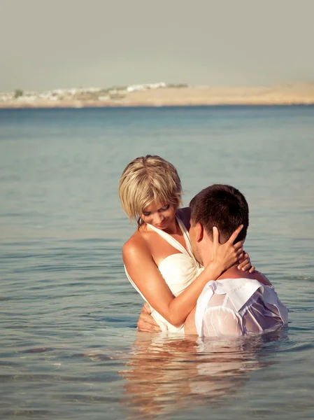 Abrazando pareja en la orilla del mar — Foto de Stock