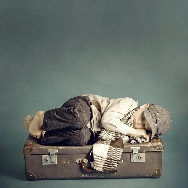 Niño durmiendo en una maleta Imagen de stock
