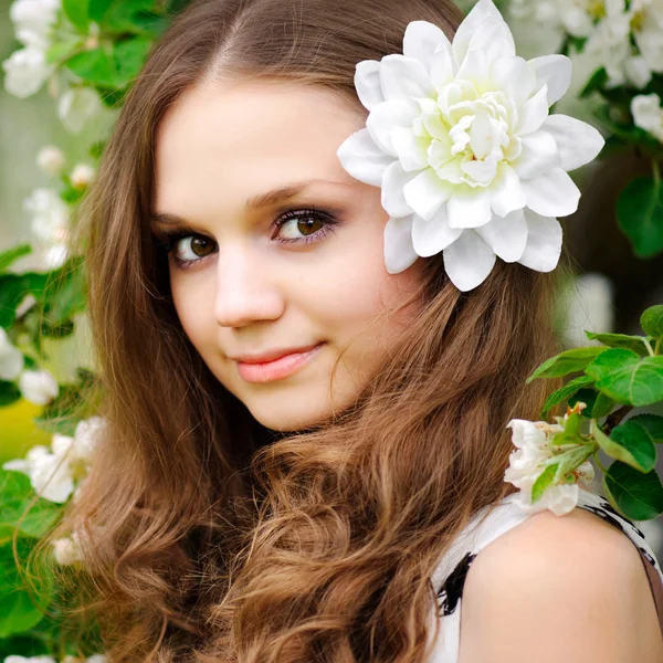 Όμορφο κορίτσι με ένα λουλούδι στα μαλλιά της — Φωτογραφία Αρχείου