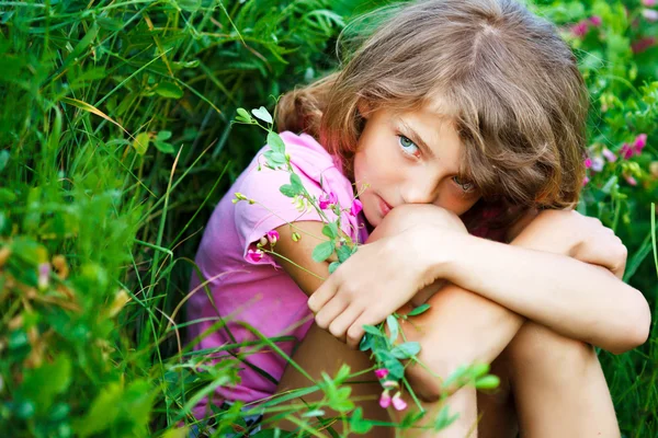 Liten flicka på fältet med blommor — Stockfoto